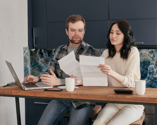 Family sitting at a desk reviewing their household budgeting checklist