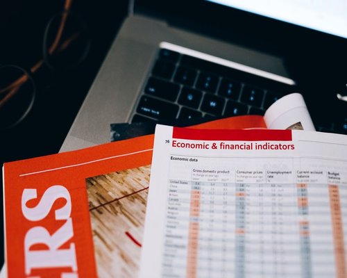 A desk with economic news reading guides